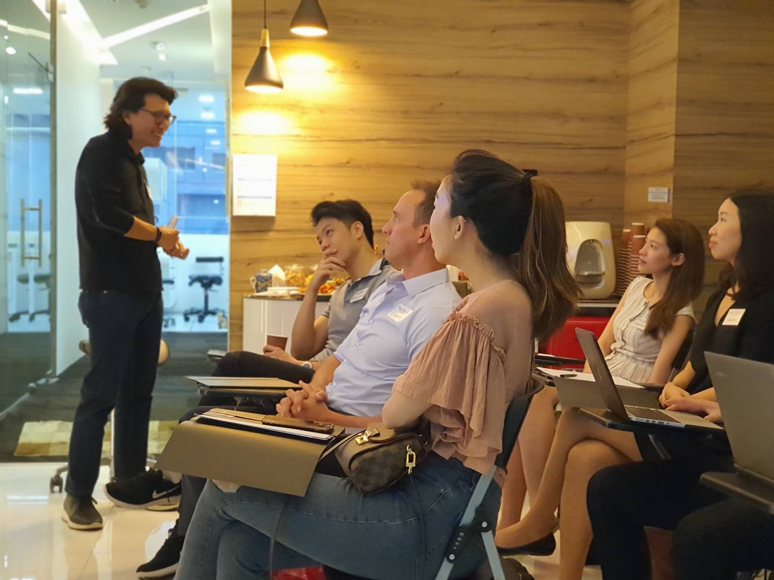 Group of professionals attentively listening to a speaker during a dental training session